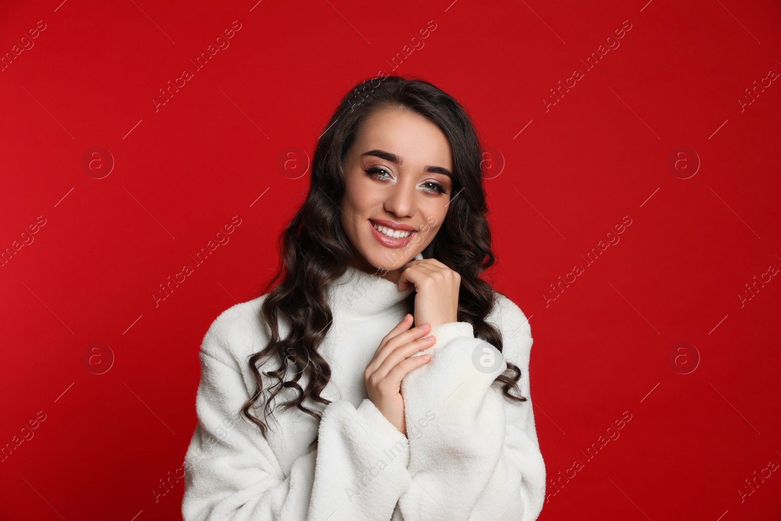 Photo of Beautiful young woman wearing warm sweater on red background. Christmas party