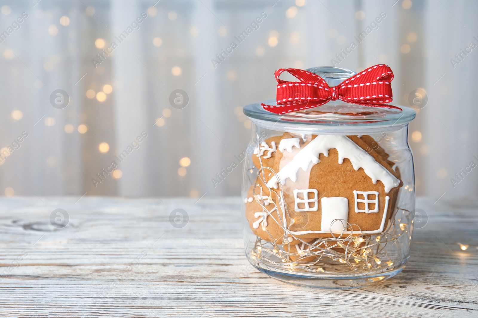 Photo of Glass jar with tasty homemade Christmas cookies on table