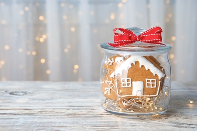 Photo of Glass jar with tasty homemade Christmas cookies on table