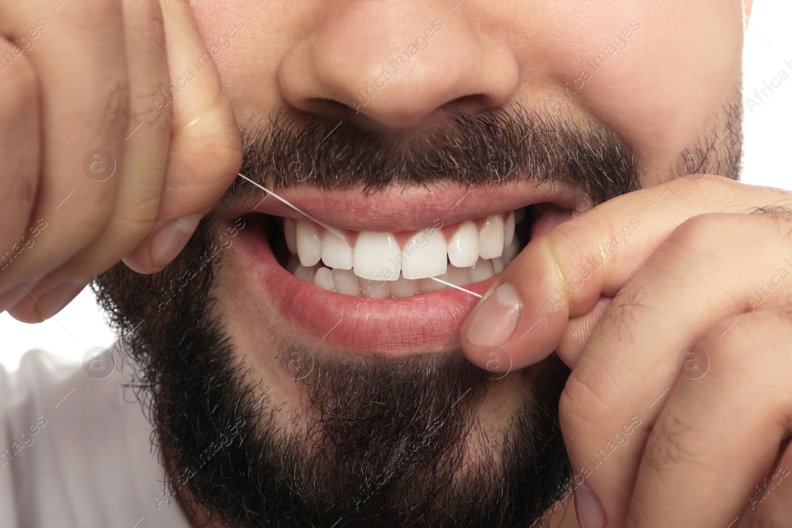 Photo of Man flossing his teeth on white background, closeup. Dental care