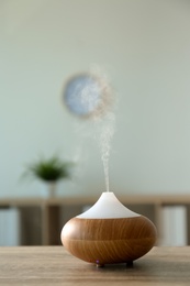 Photo of Modern aroma lamp on table in room