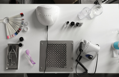 Professional equipment for manicure on table in beauty salon, top view