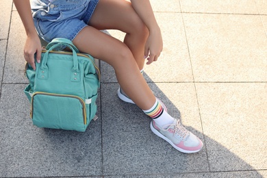 Young woman with stylish turquoise bag on city street, closeup