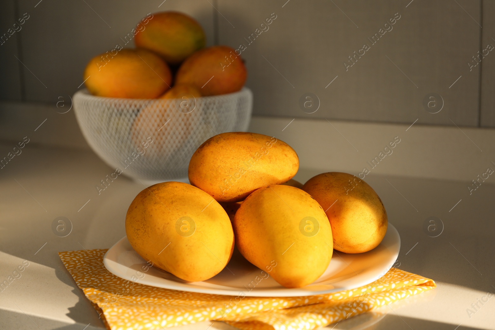 Photo of Delicious ripe mangos on white table indoors
