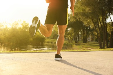 Photo of Man running near pond in park, closeup