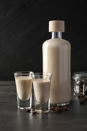 Coffee cream liqueur in glasses, bottle and beans on grey table