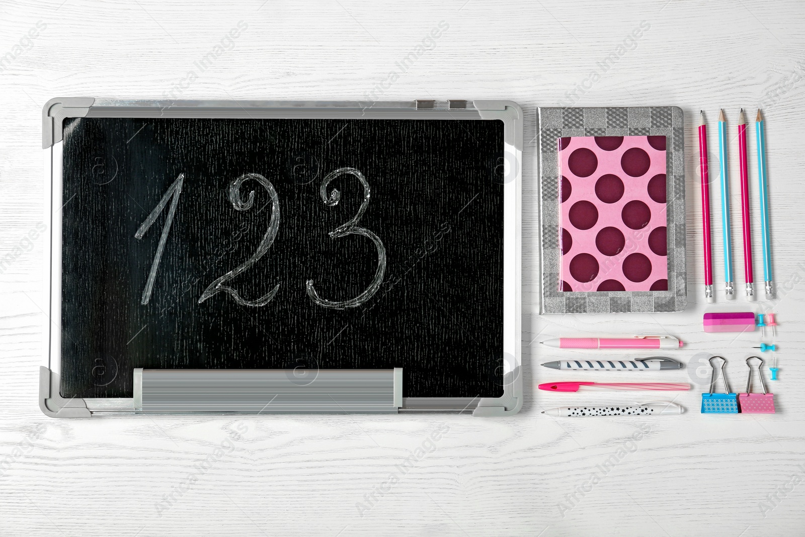 Photo of Flat lay composition with different school stationery and small chalkboard on wooden background