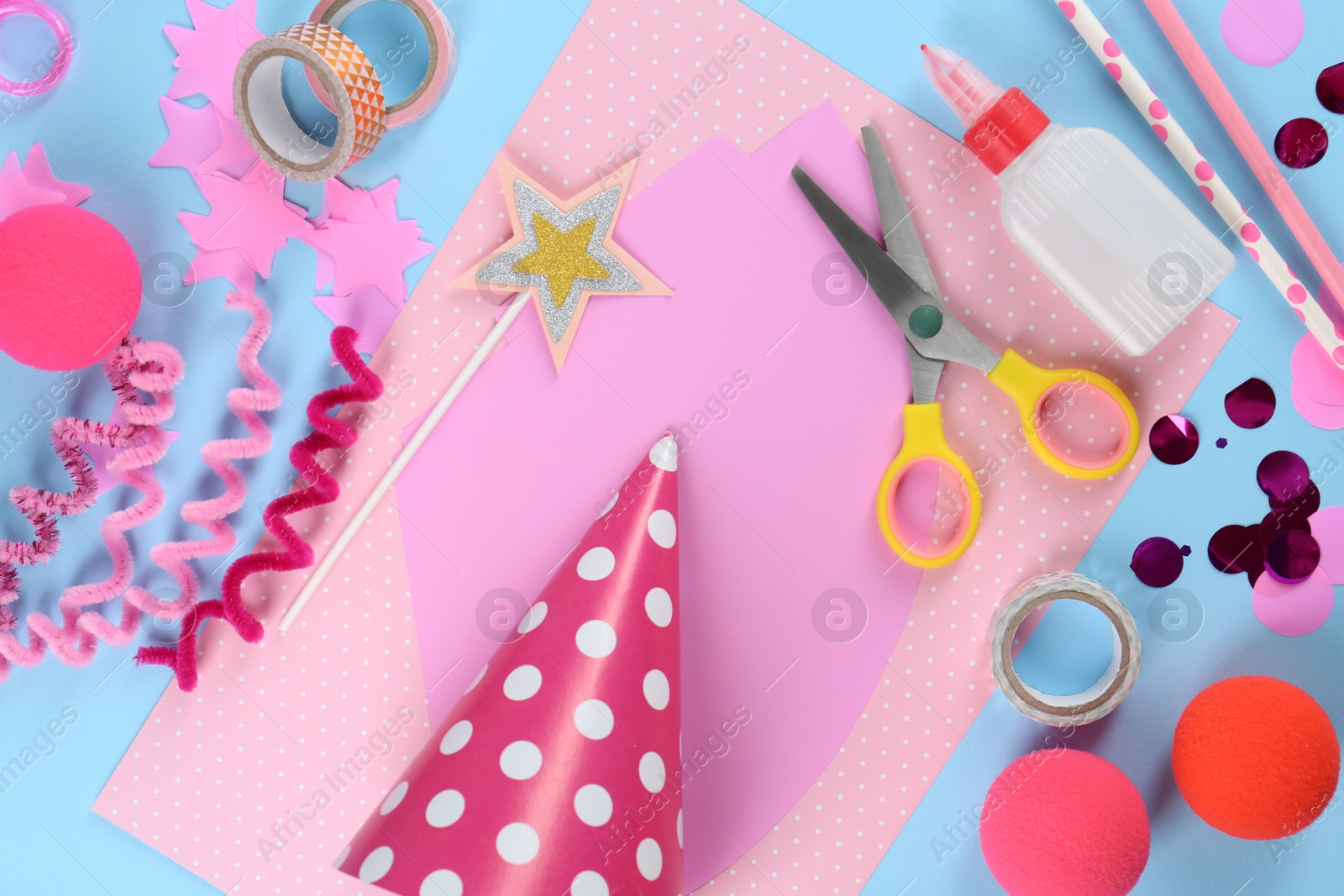 Photo of Flat lay composition with different materials to create party hats on light blue background. Handmade decoration