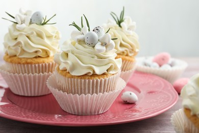 Tasty Easter cupcakes with vanilla cream on table, closeup