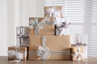 Photo of Heap of wrapped gift boxes on wooden table. Happy holiday