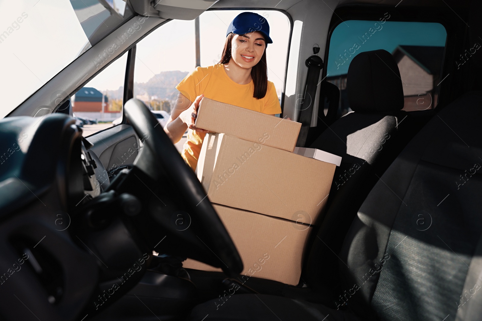 Photo of Courier taking parcel from car. Delivery service