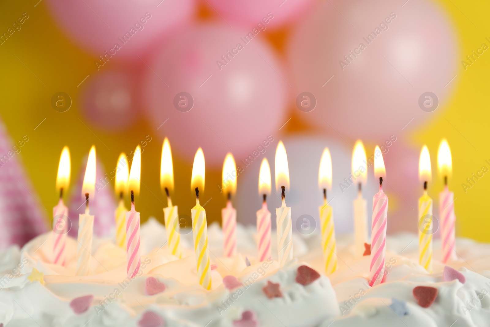 Photo of Birthday cake with burning candles on blurred background, closeup