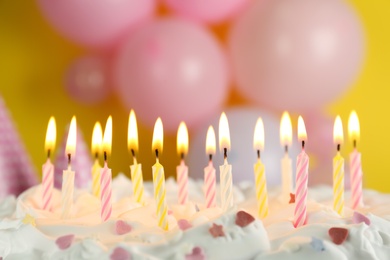Photo of Birthday cake with burning candles on blurred background, closeup