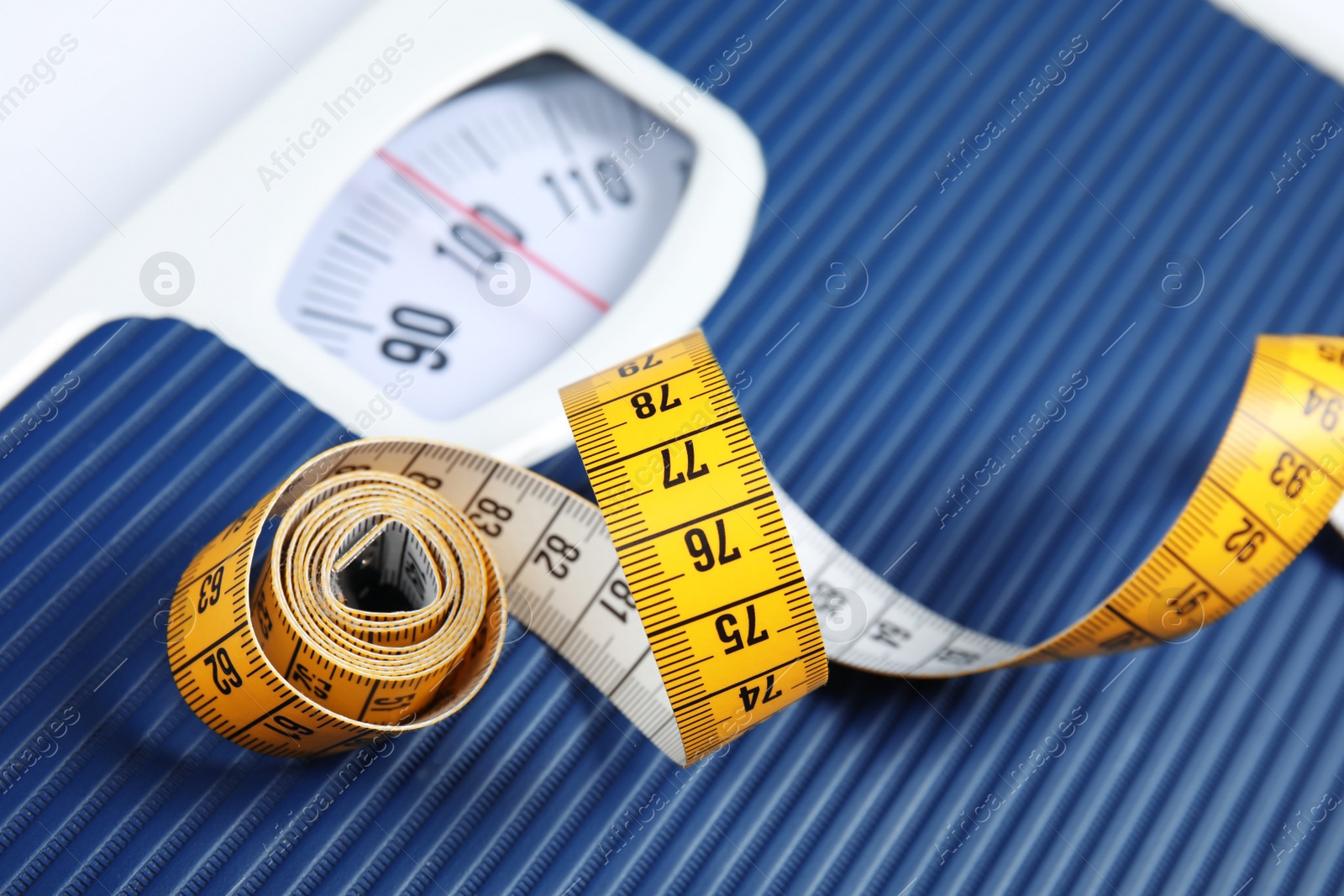 Photo of Scales with tape measure, closeup view. Diet and weight loss