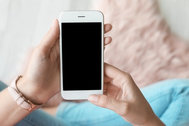 Woman using smartphone with blank screen, closeup. Mock up for design