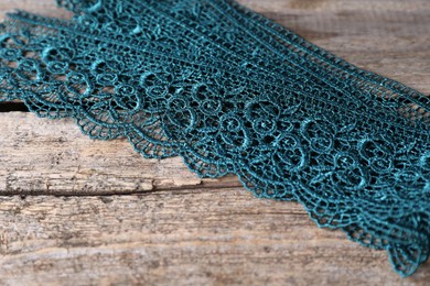 Photo of Beautiful lace on wooden table, closeup view