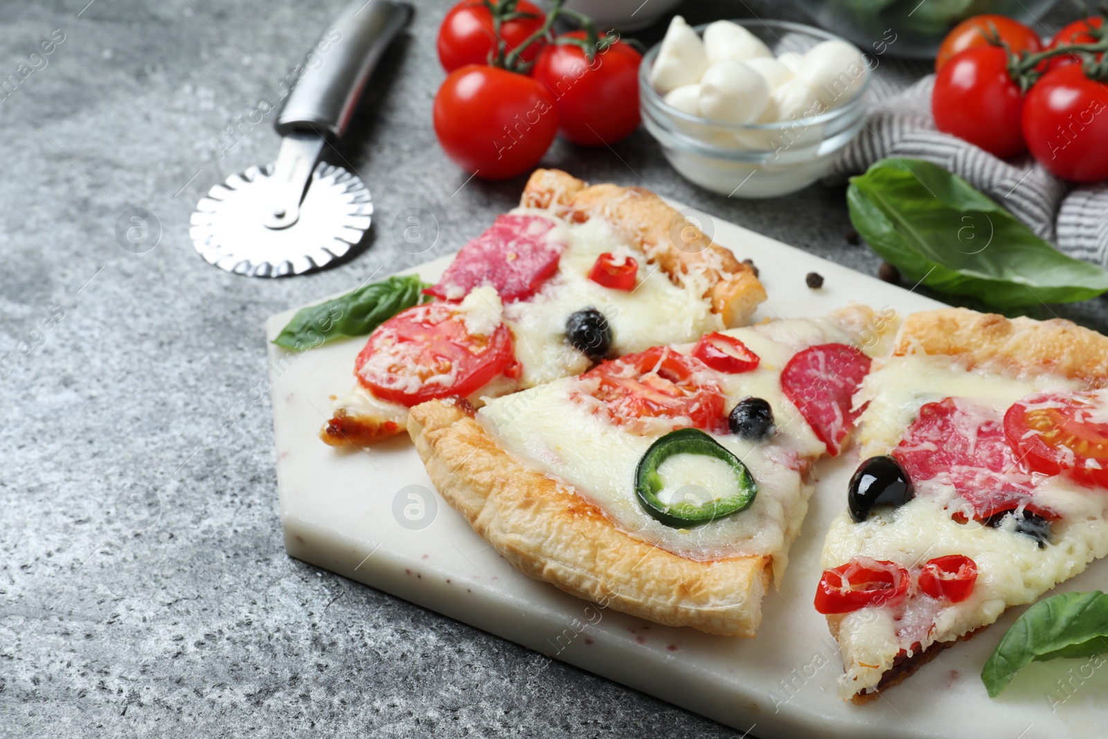 Photo of Composition with pieces of delicious pizza Diablo on  dark background, closeup