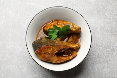 Photo of Tasty fish curry on light grey table, top view. Indian cuisine