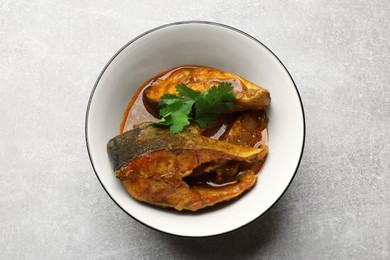 Tasty fish curry on light grey table, top view. Indian cuisine