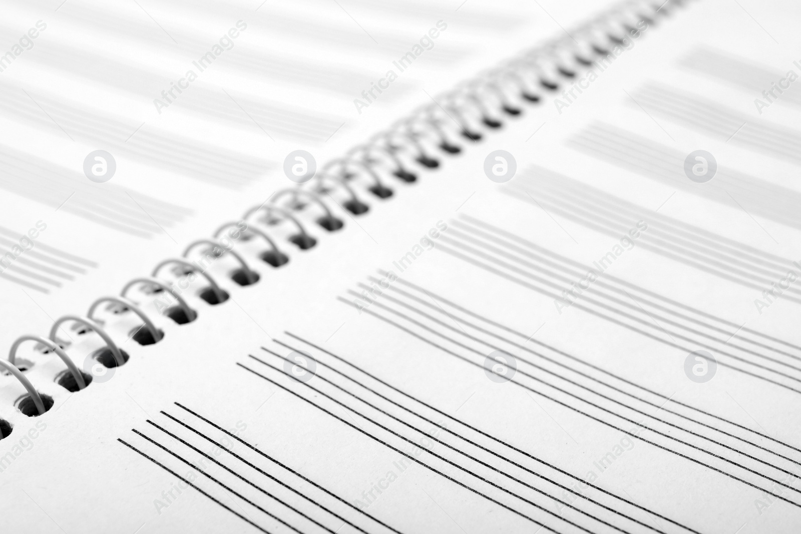 Photo of Notebook with empty staves for music notes as background, closeup