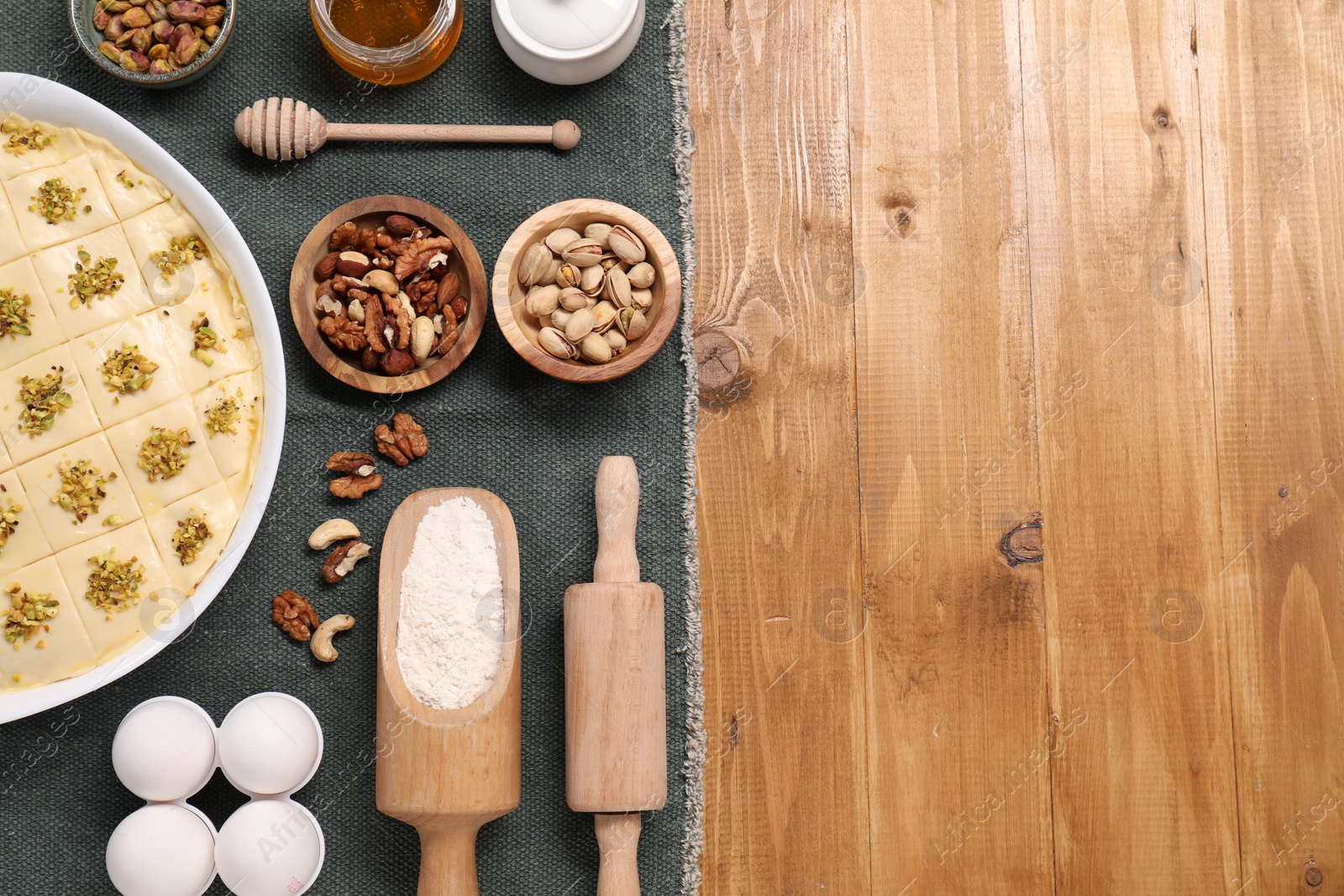 Photo of Making delicious baklava. Raw dough with ingredients on wooden table, flat lay. Space for text