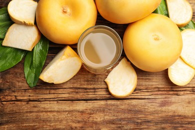 Photo of Glass of freshly made turnip juice on wooden table, flat lay