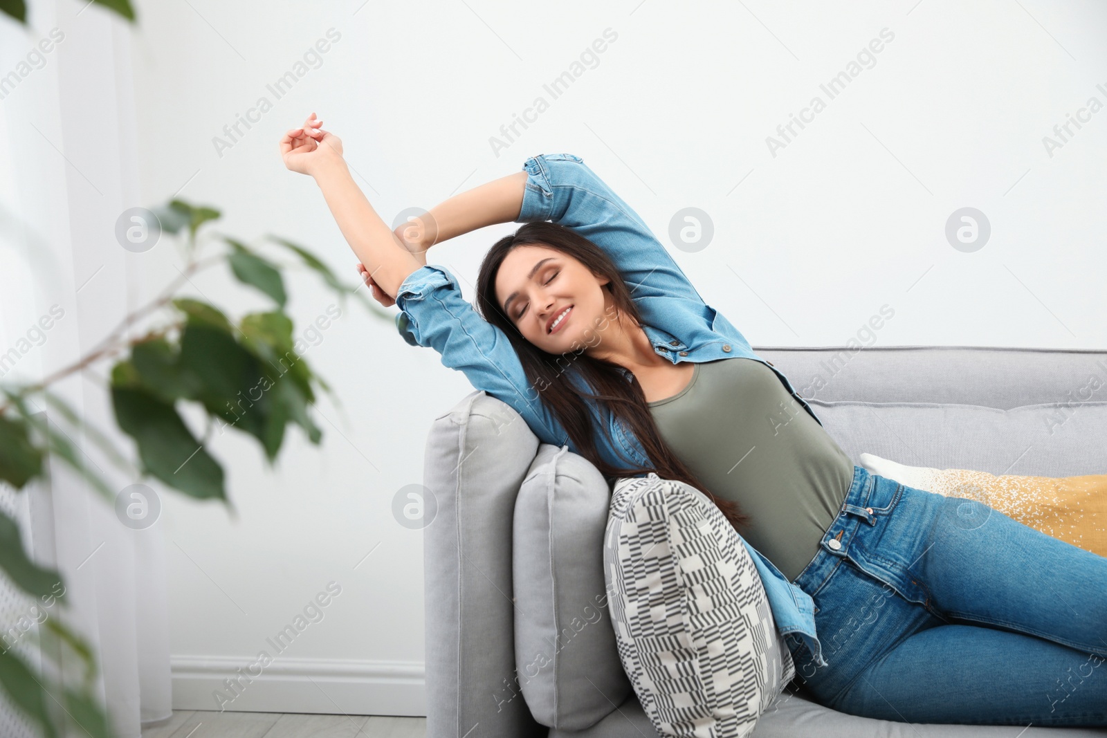 Photo of Young woman relaxing on couch at home