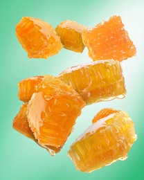 Image of Pieces of honeycomb falling on aquamarine background