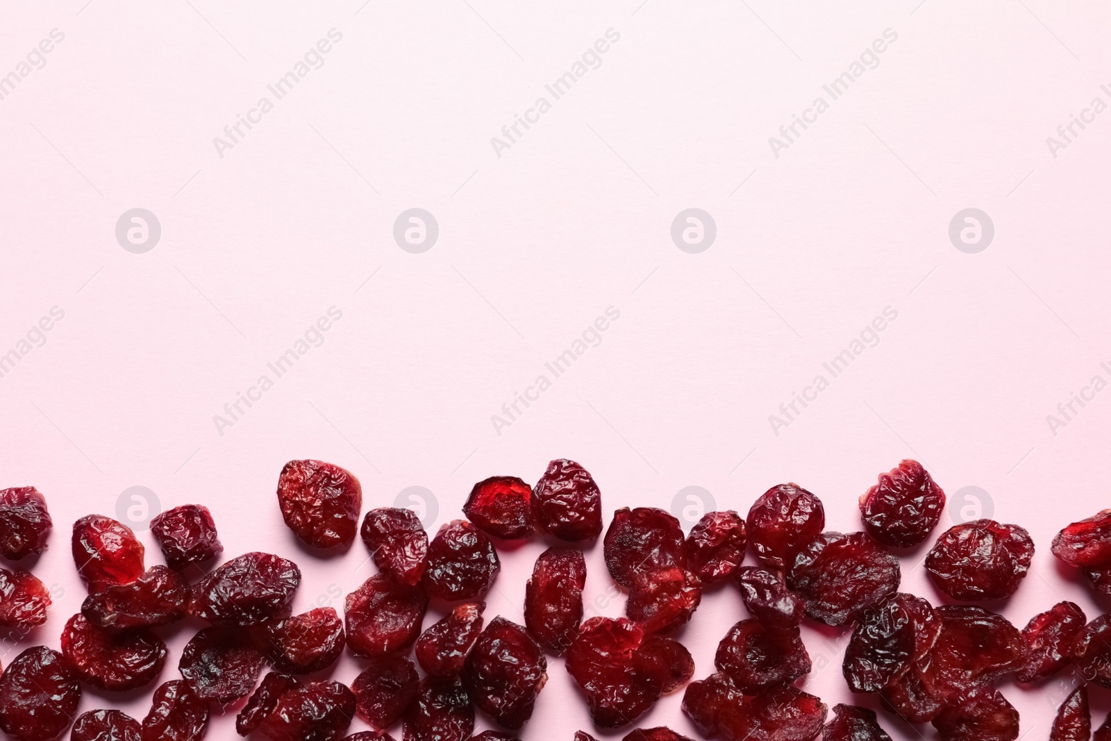 Photo of Cranberries on color background, top view with space for text. Dried fruit as healthy snack