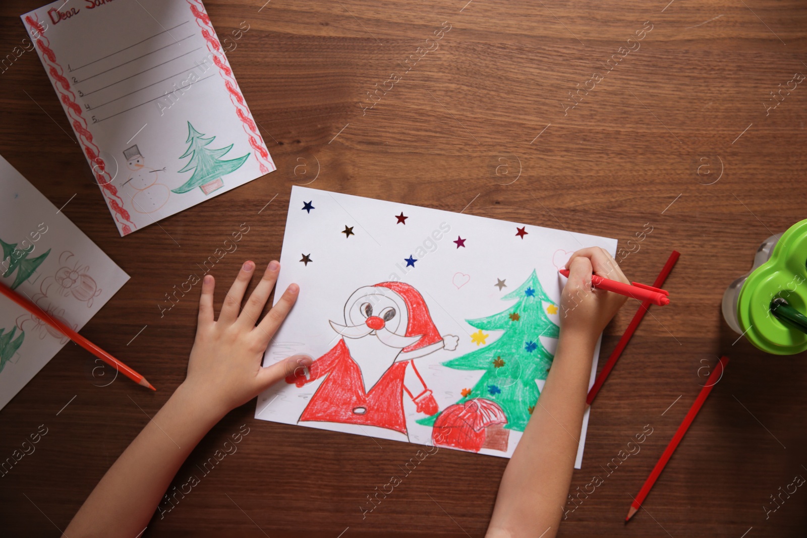 Photo of Little child drawing picture at table, top view. Christmas celebration