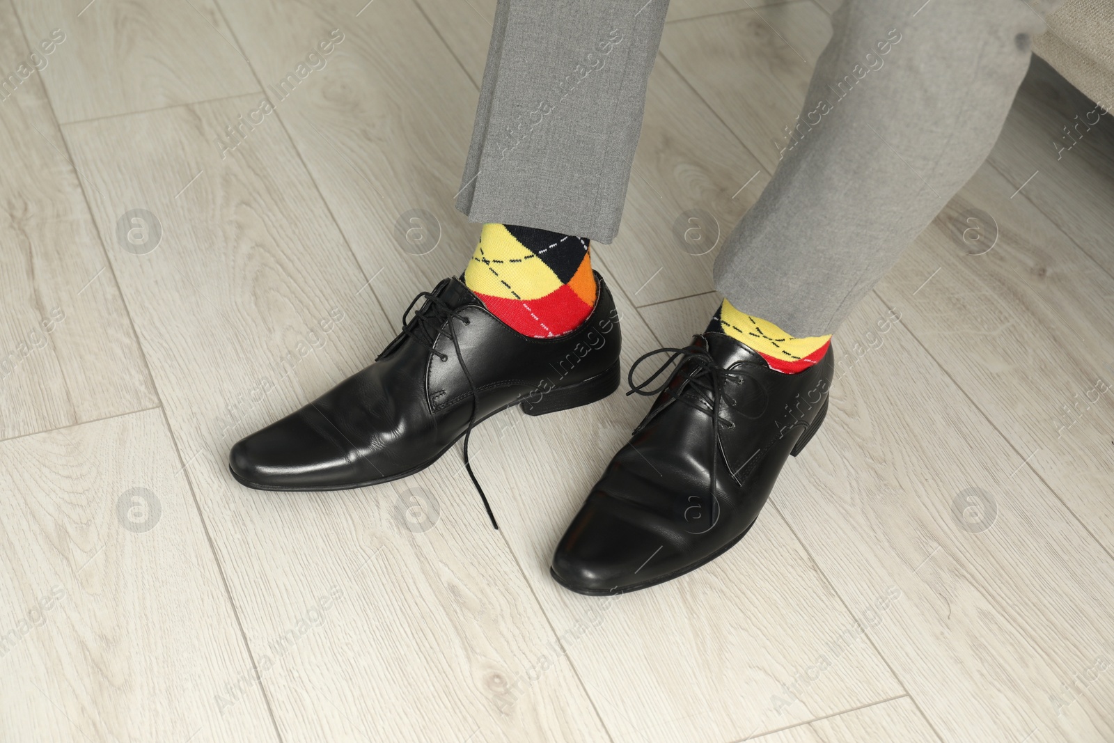 Photo of Man wearing stylish shoes and colorful socks indoors, closeup