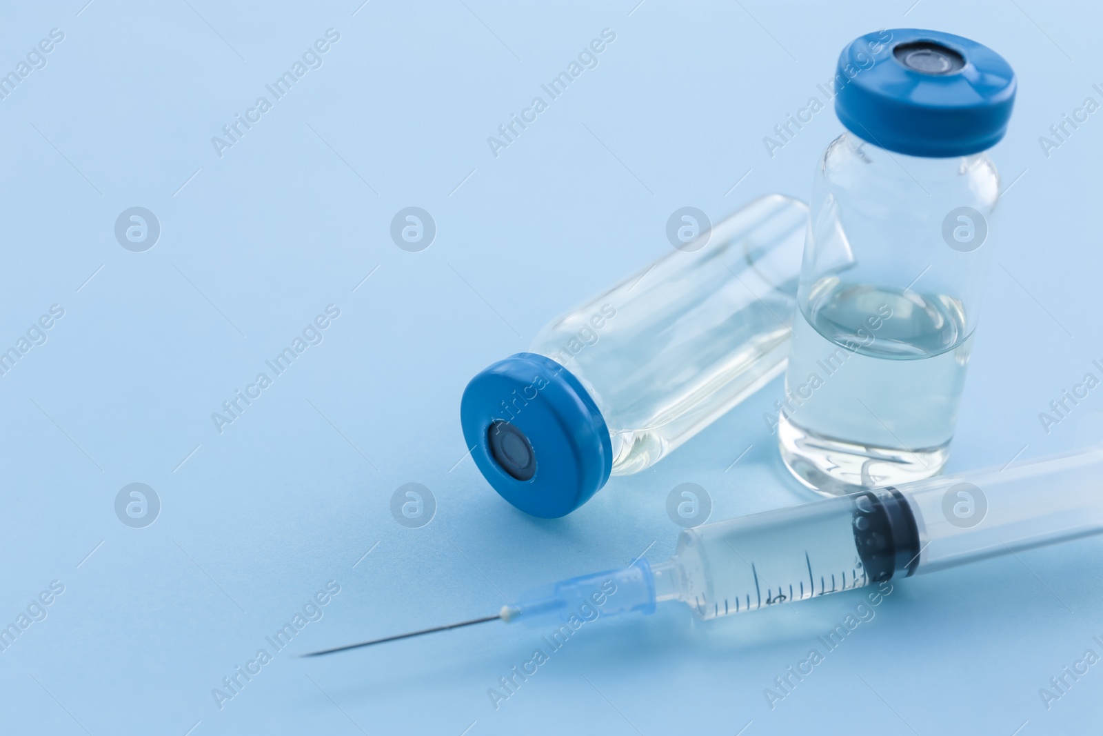 Photo of Vials with vaccine and syringe on color background