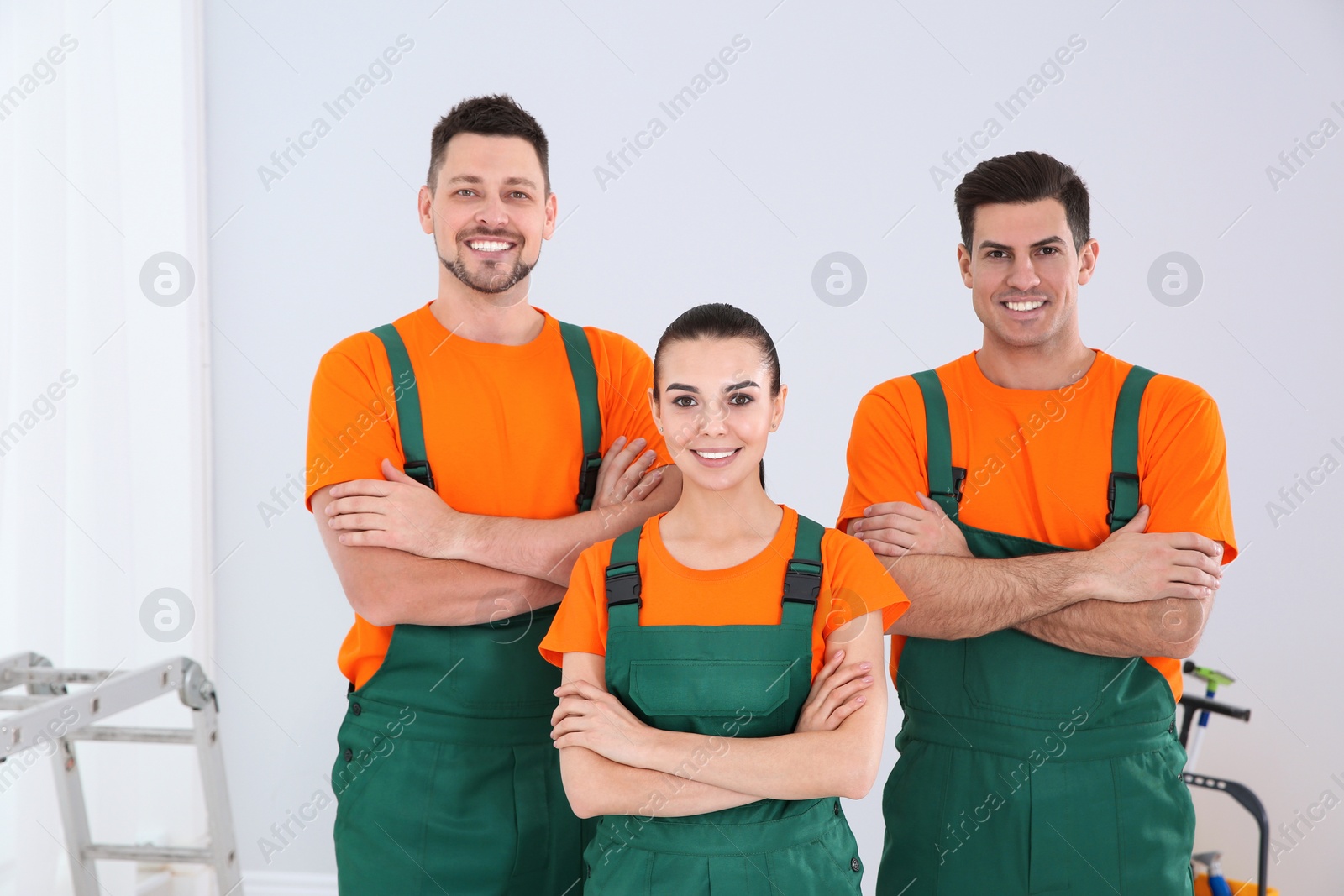 Photo of Team of professional janitors in uniform indoors. Cleaning service