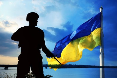 Stop war in Ukraine. Silhouette of armed soldier outdoors and Ukrainian flag, double exposure effect