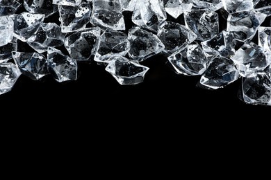 Photo of Heap of crushed ice on black table, closeup. Space for text