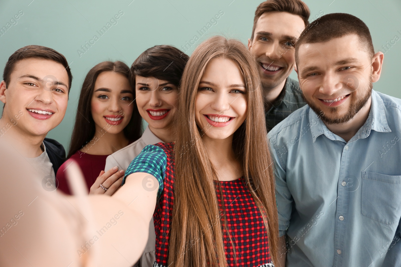 Photo of Happy friends taking selfie on color background