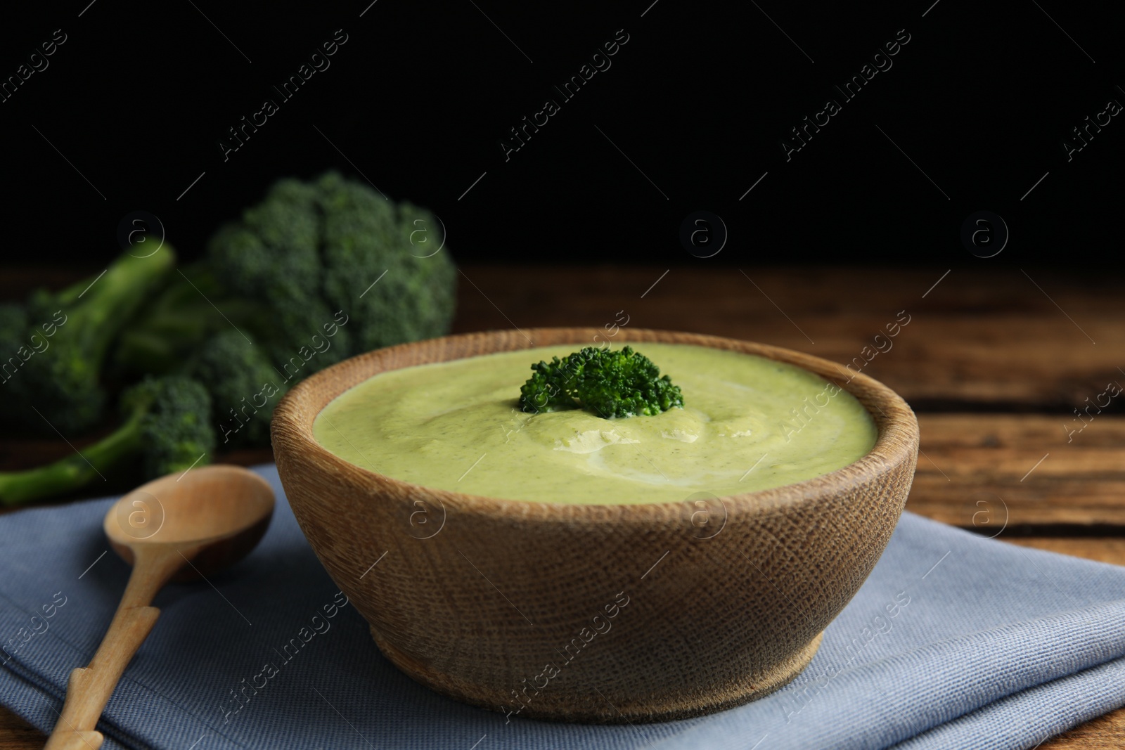 Photo of Delicious broccoli cream soup served on wooden table