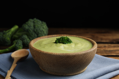 Photo of Delicious broccoli cream soup served on wooden table