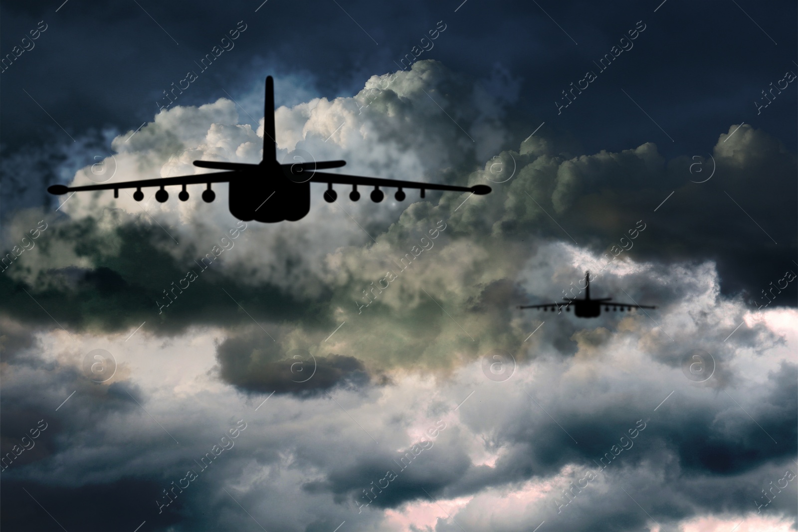 Image of Silhouettes of jet fighters in cloudy sky