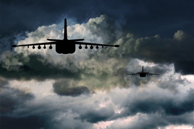 Image of Silhouettes of jet fighters in cloudy sky