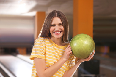 Photo of Young woman with ball in bowling club