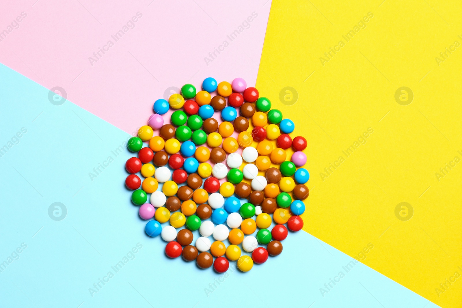 Photo of Delicious bright glazed candies on color background, top view