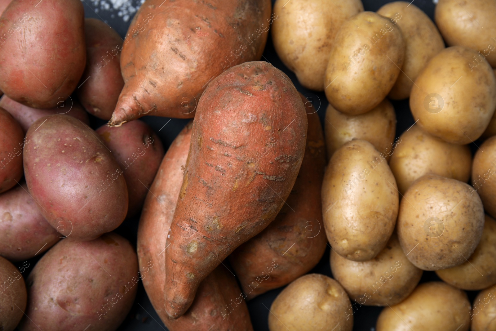 Photo of Different types of fresh potatoes as background, top view