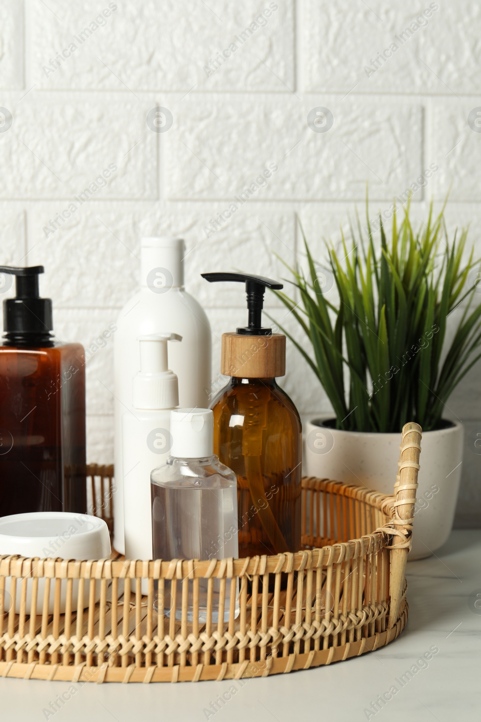 Photo of Bath accessories. Personal care products on white table near brick wall