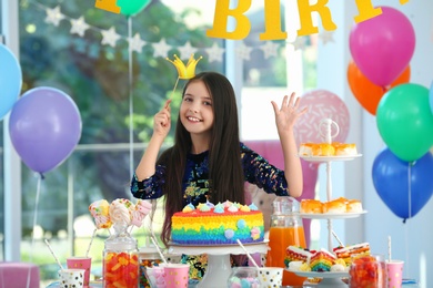 Photo of Happy girl in room decorated for birthday party