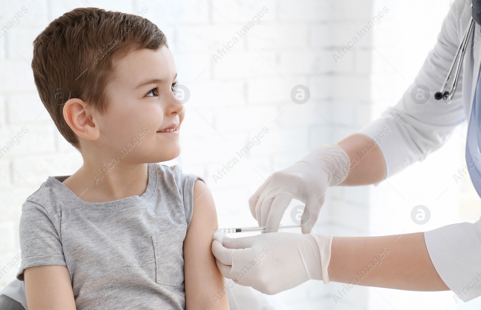 Photo of Doctor vaccinating little boy in hospital