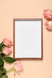 Photo of Empty photo frame and beautiful flowers on beige background, flat lay. Space for design