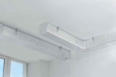 Photo of Ceiling with ventilation system indoors, low angle view