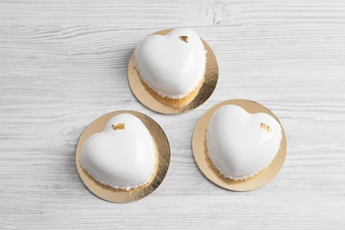 Photo of St. Valentine's Day. Delicious heart shaped cakes on white wooden table, flat lay