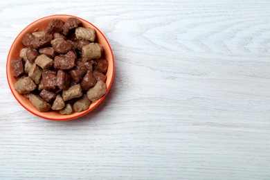Photo of Wet pet food in feeding bowl on white wooden table, top view. Space for text